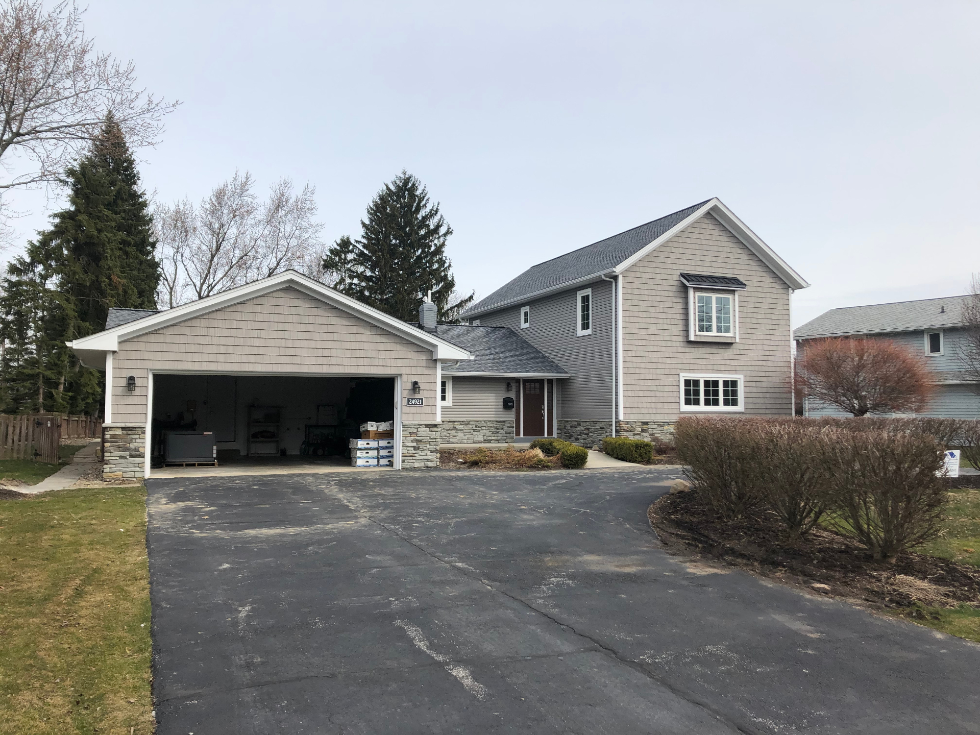 Home exterior with new shake siding, stone accents and attached garage