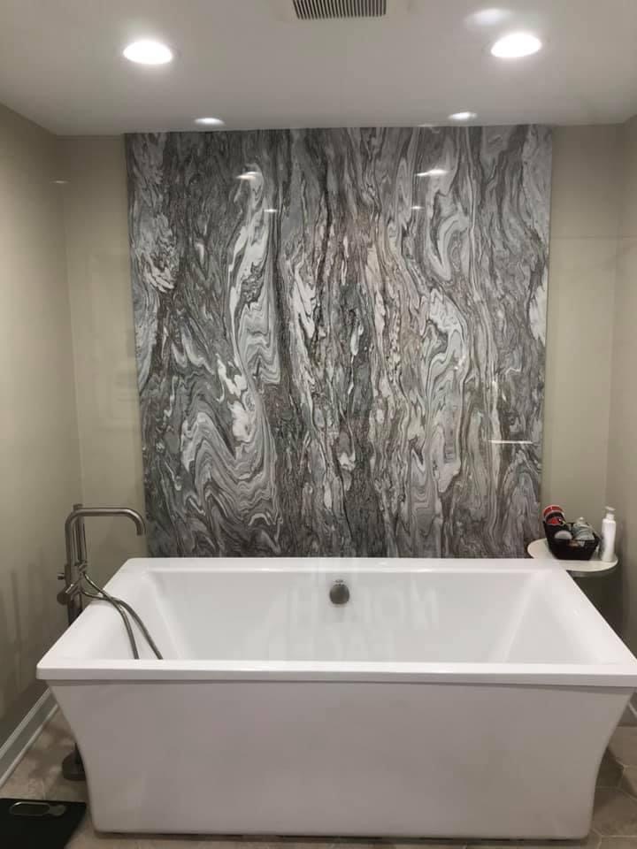 Freestanding soaker tub against a dramatic marble feature wall