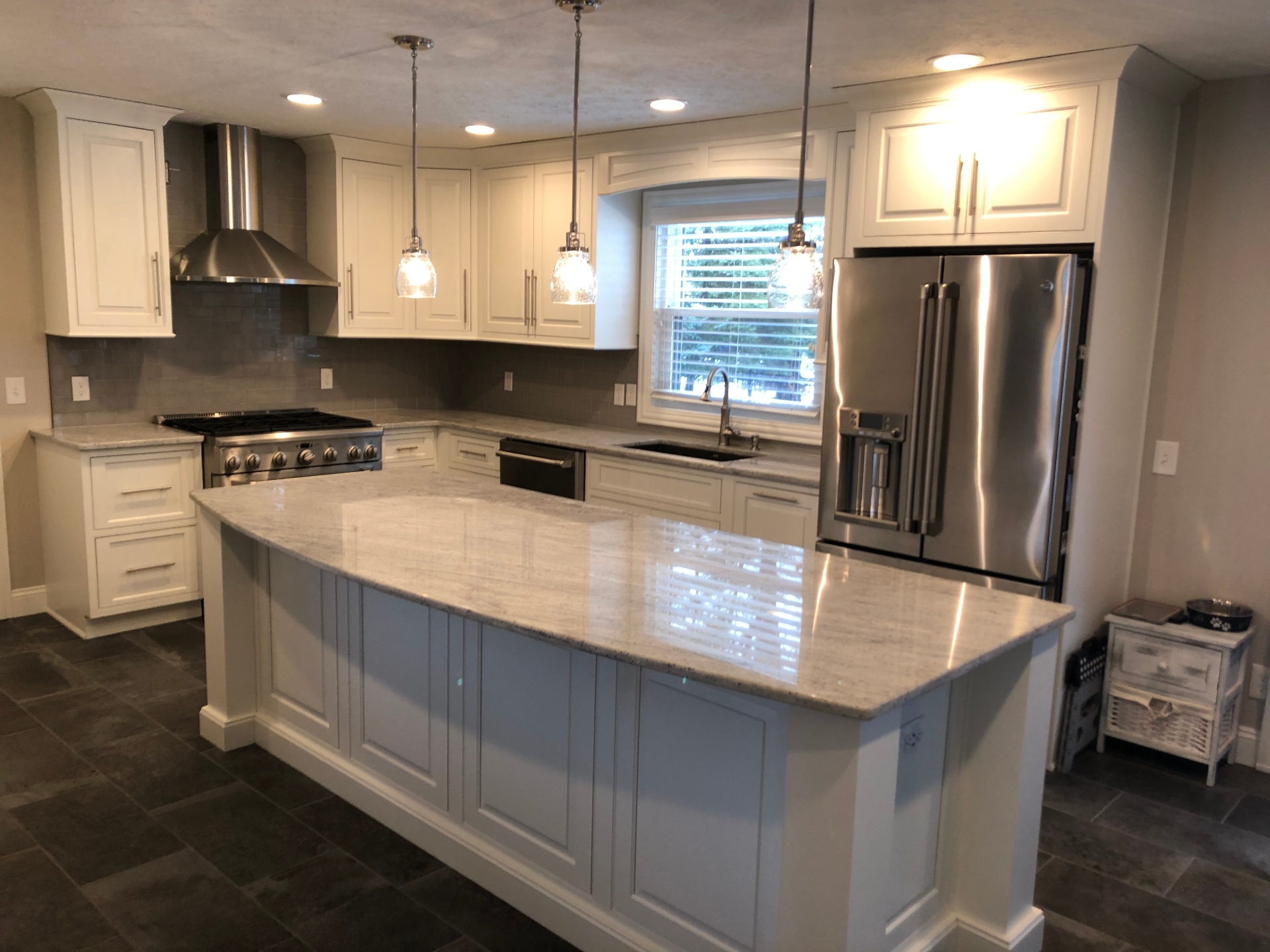 Open kitchen with granite island, pendant lights and stainless appliances